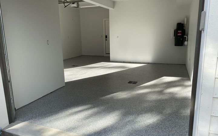 Sunlit two-car garage with a light gray flake floor