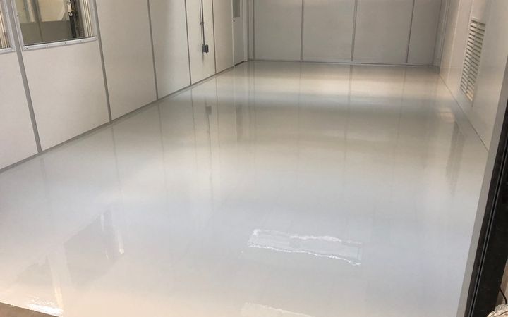 Glossy white solid color floor reflecting the walls of an empty room